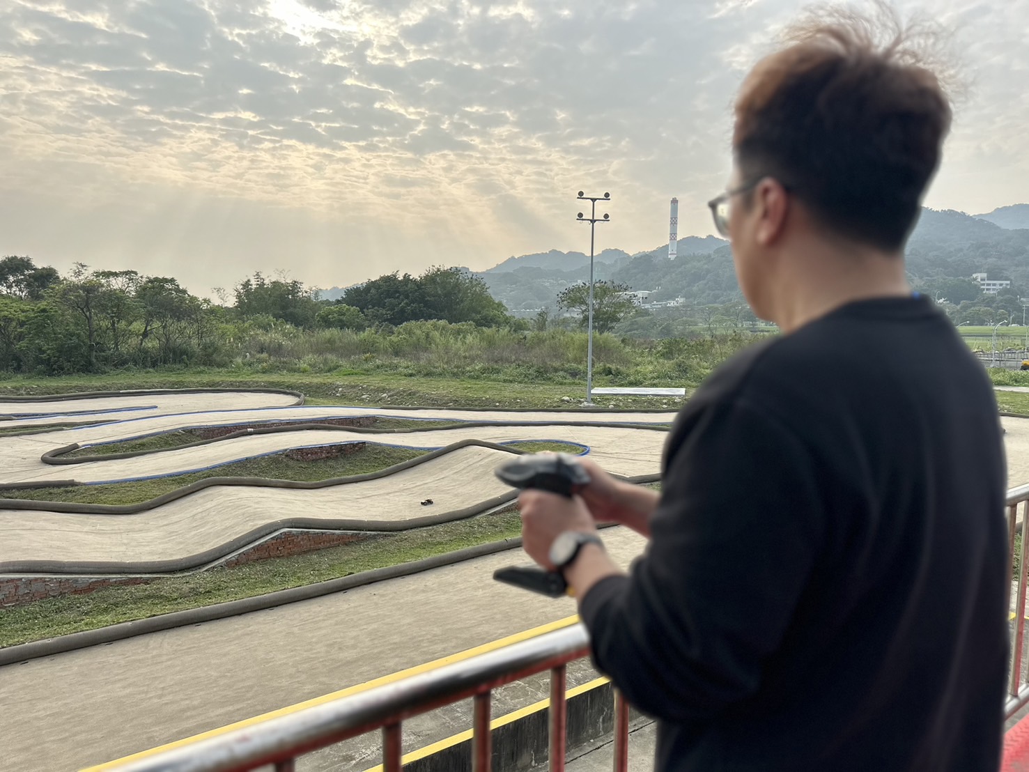 車友正專注地操作遙控器，盡情享受著競速的刺激與樂趣。