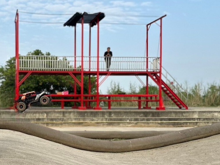 一輛越野遙控車在新設置的跳台上空中飛躍，展現出玩家們的操控技巧和車輛性能。
