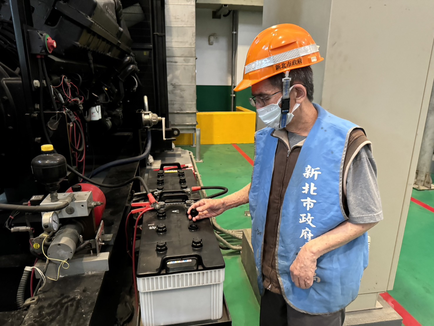 抽水站站員檢查柴油引擎電瓶水位，確保引擎運作安全