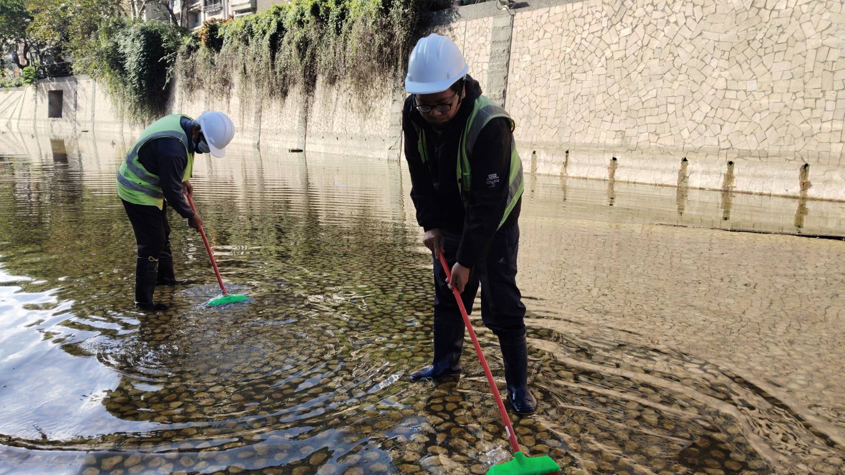 現場作業採人工方式進行清洗，以保護底部卵石