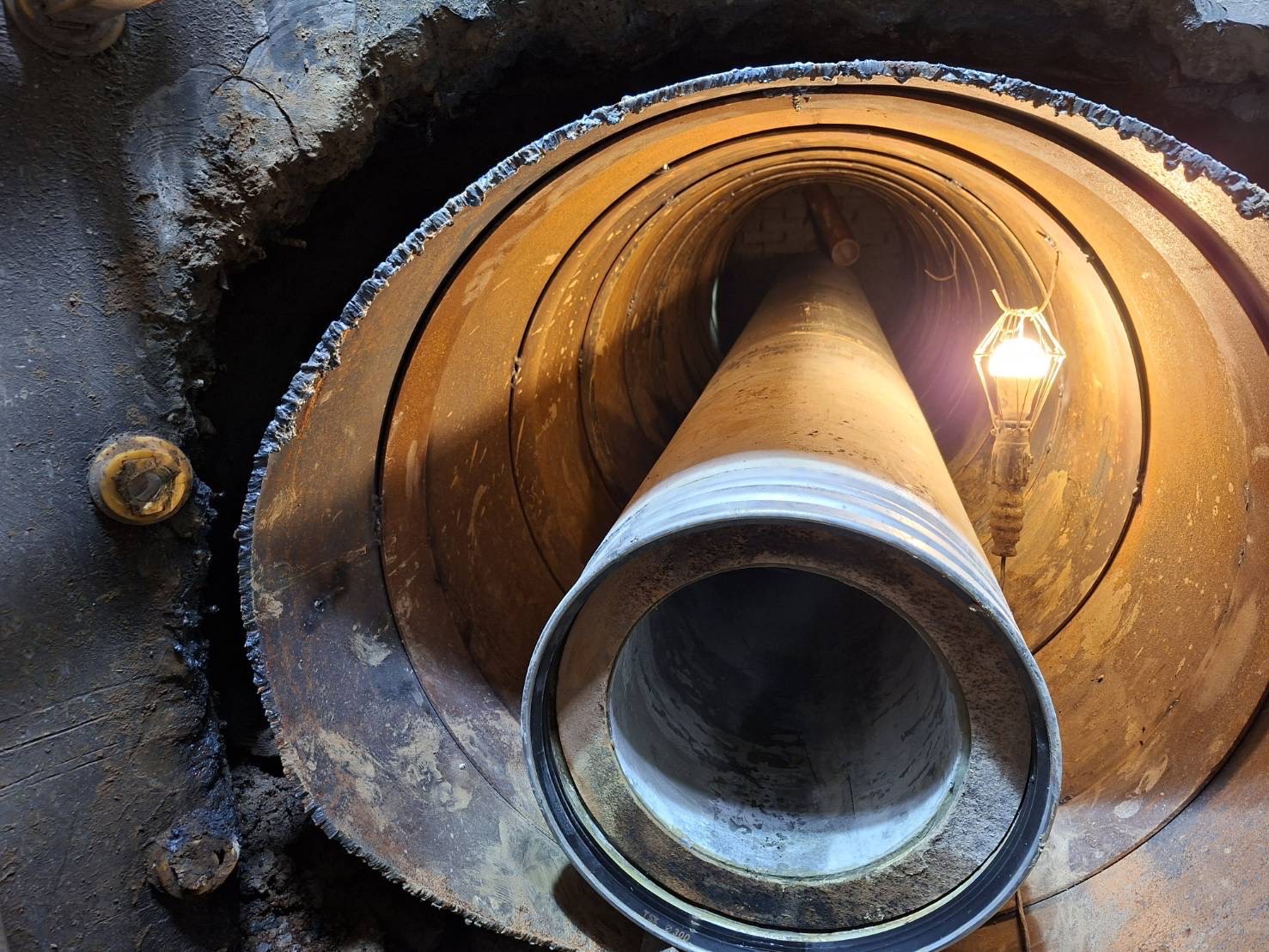 施工人員從既有人孔內部進行鋼套管推進，將污水管線順利接入