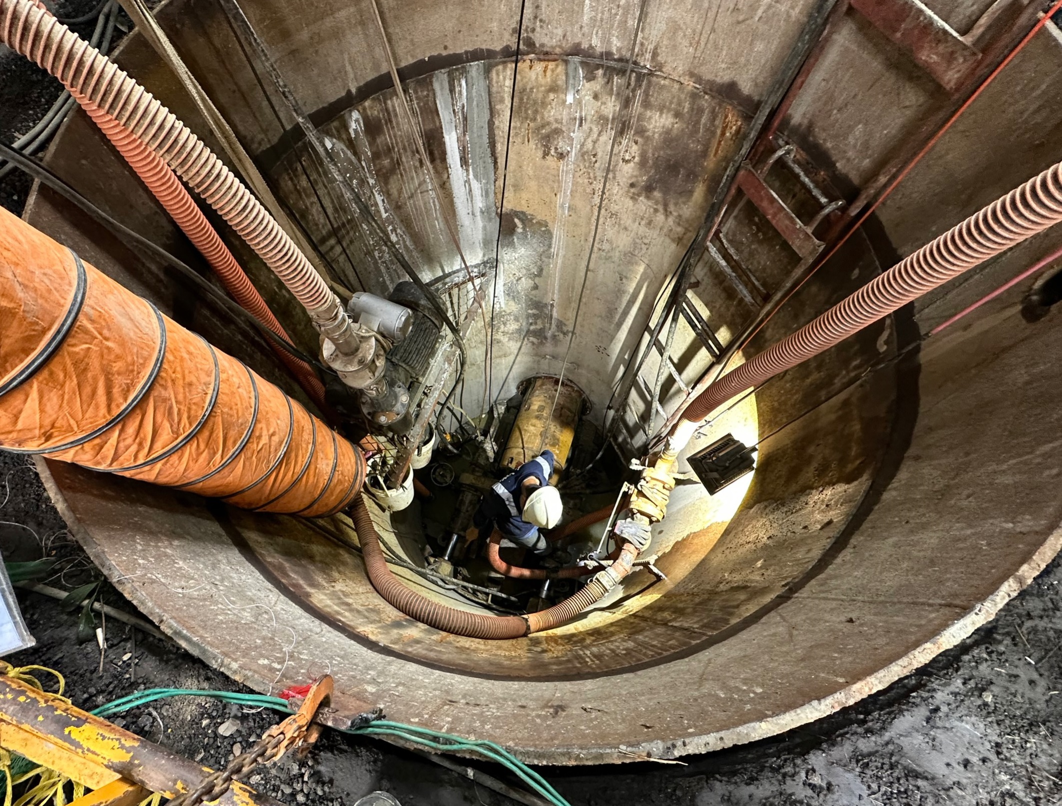 施工人員辛苦的在工作井中進行地下污水管線推進